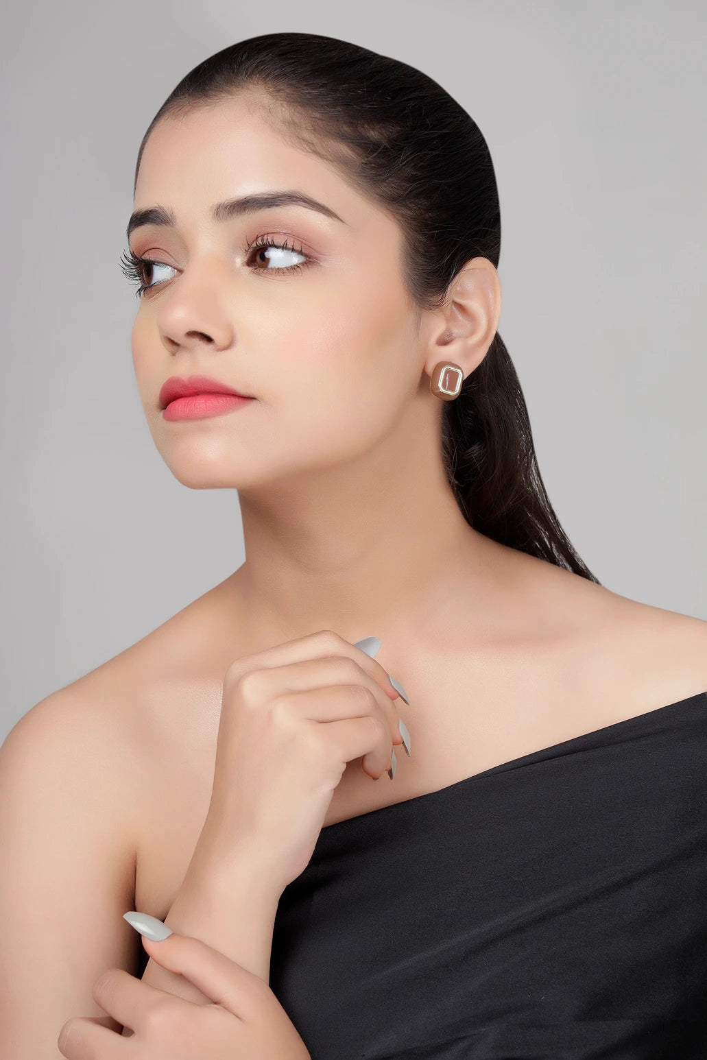 Café enamel stud earrings in brown with gold finish on model side pose