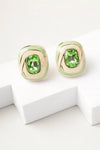erde swirl stud earrings with green crystal and gold enamel detailing on white background