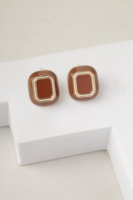 Close-up view of brown enamel gold stud earrings with geometric design