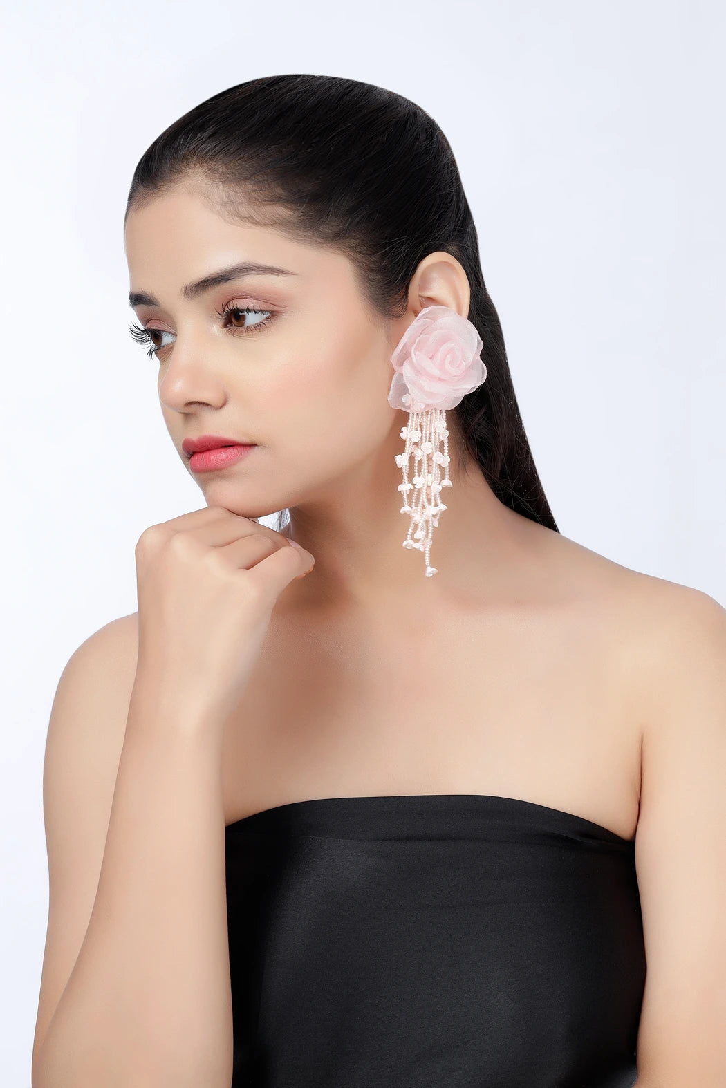 Model wearing blush cascade pink floral pearl statement earrings front view