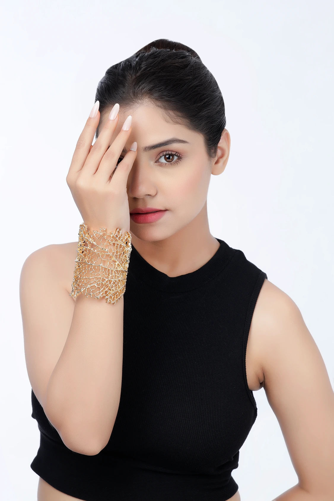 Model wearing Coral Reef gold cuff bracelet with openwork design