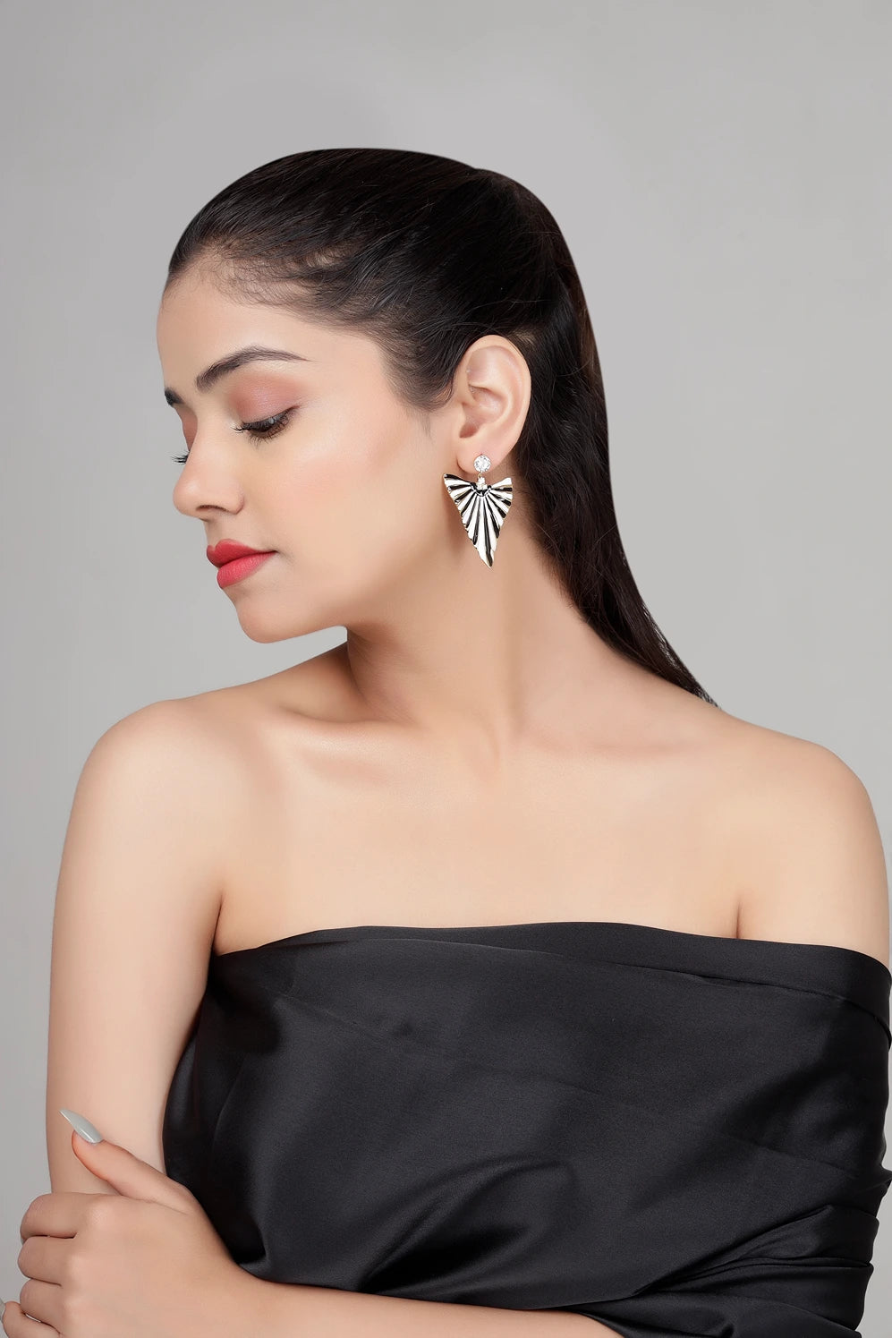 Side view of Eclipse Fan statement earrings worn by model