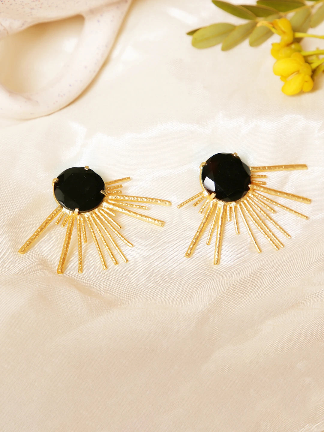 Profile view of black onyx gold sunburst statement earrings