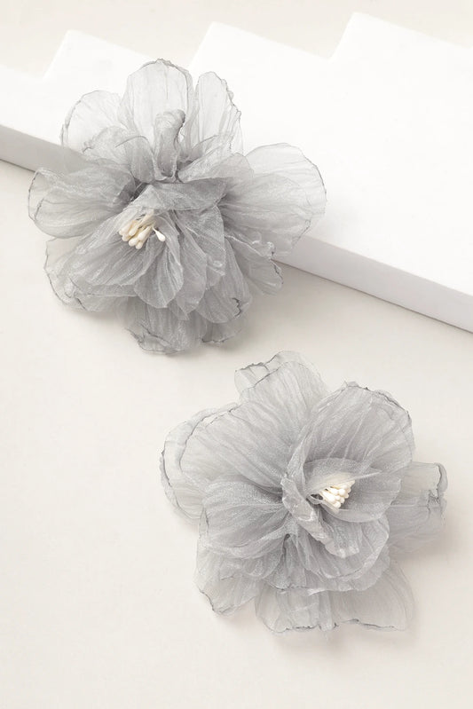 Styled shot of silver mist grey organza floral earrings on white blocks