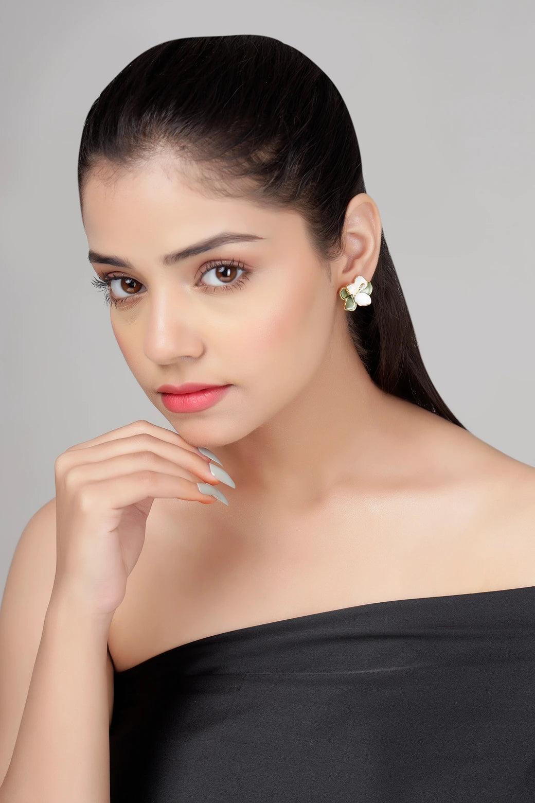 Close-up of verdant bloom floral stud earrings worn on ear