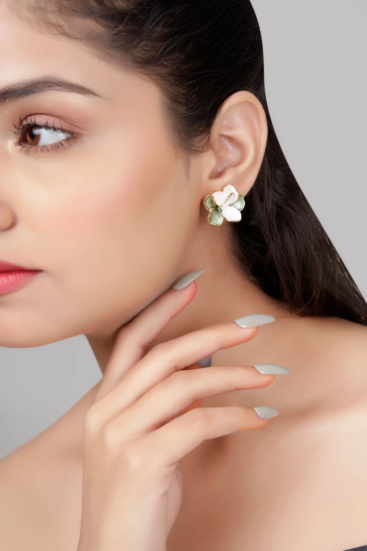 Model wearing verdant bloom green and white enamel floral stud earrings